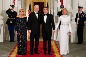 texto alternativo para imágenes. Joe Biden y Emmanuel Macron sonriendo juntos a cámara, de la mano de sus esposas: Jill Biden y Brigitte Macron